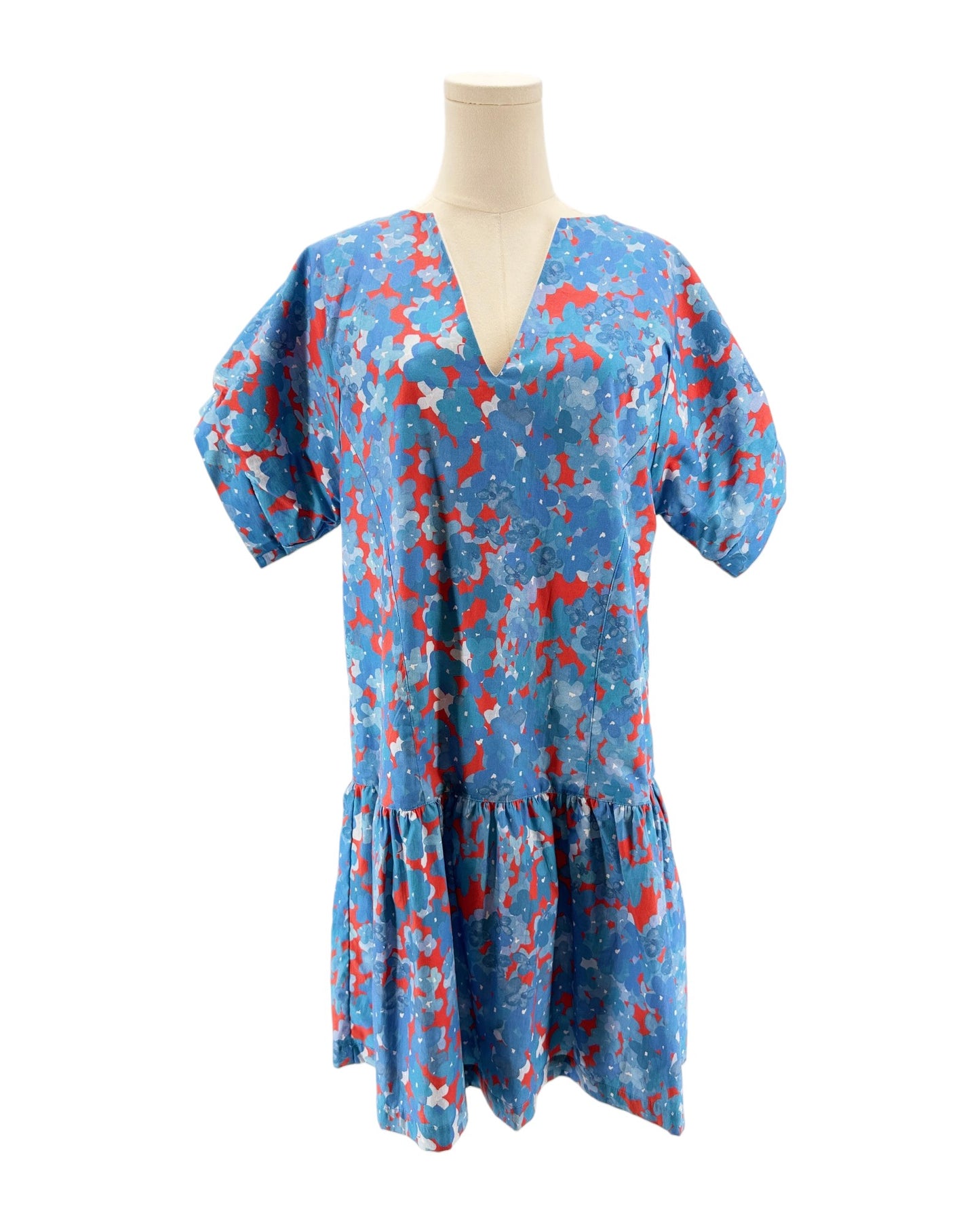 Blue dress with red and white pattern on a mannequin against a white background