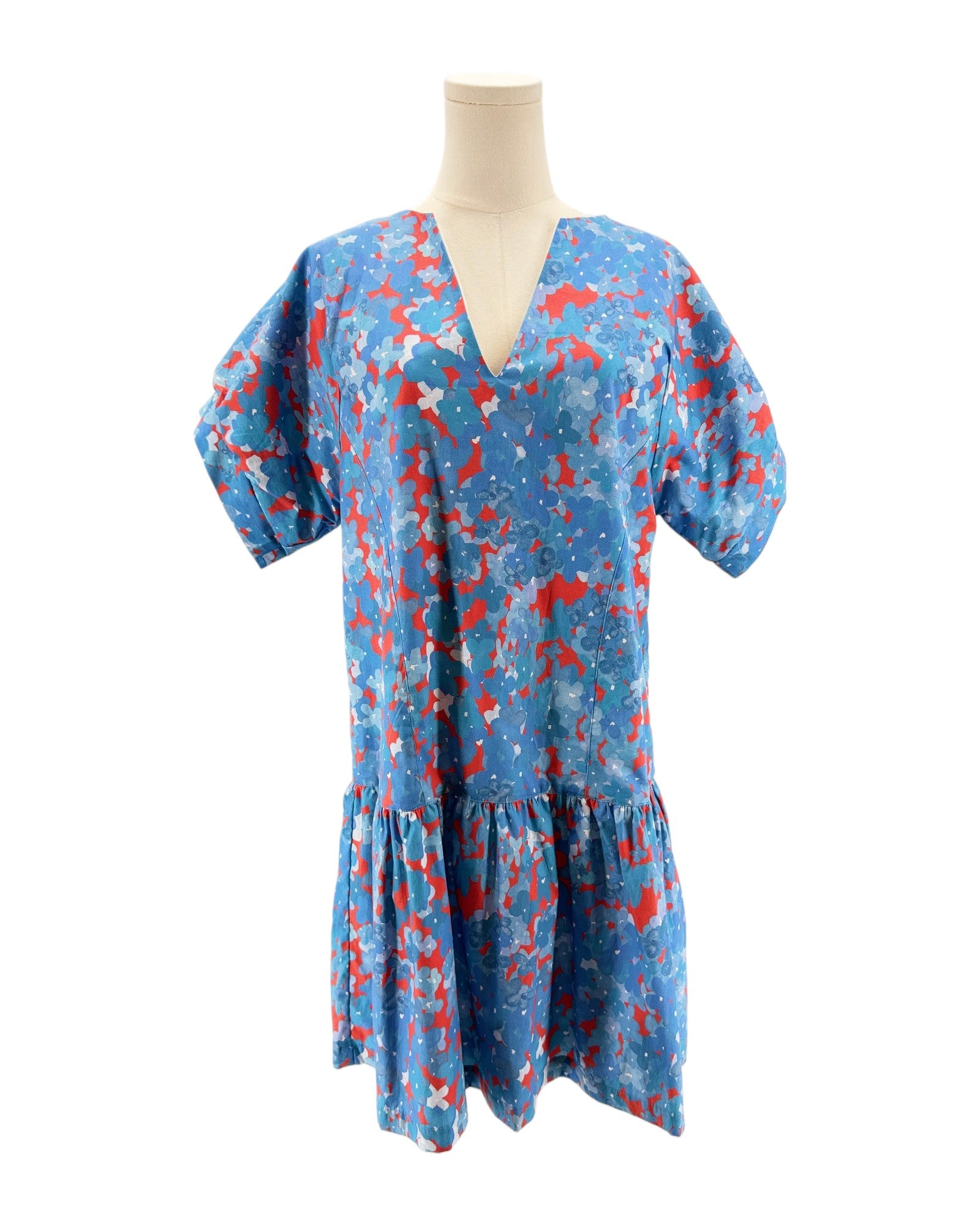 Blue dress with red and white pattern on a mannequin against a white background