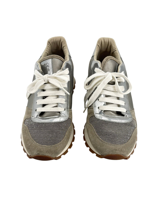 Pair of gray sneakers with white laces on a white background