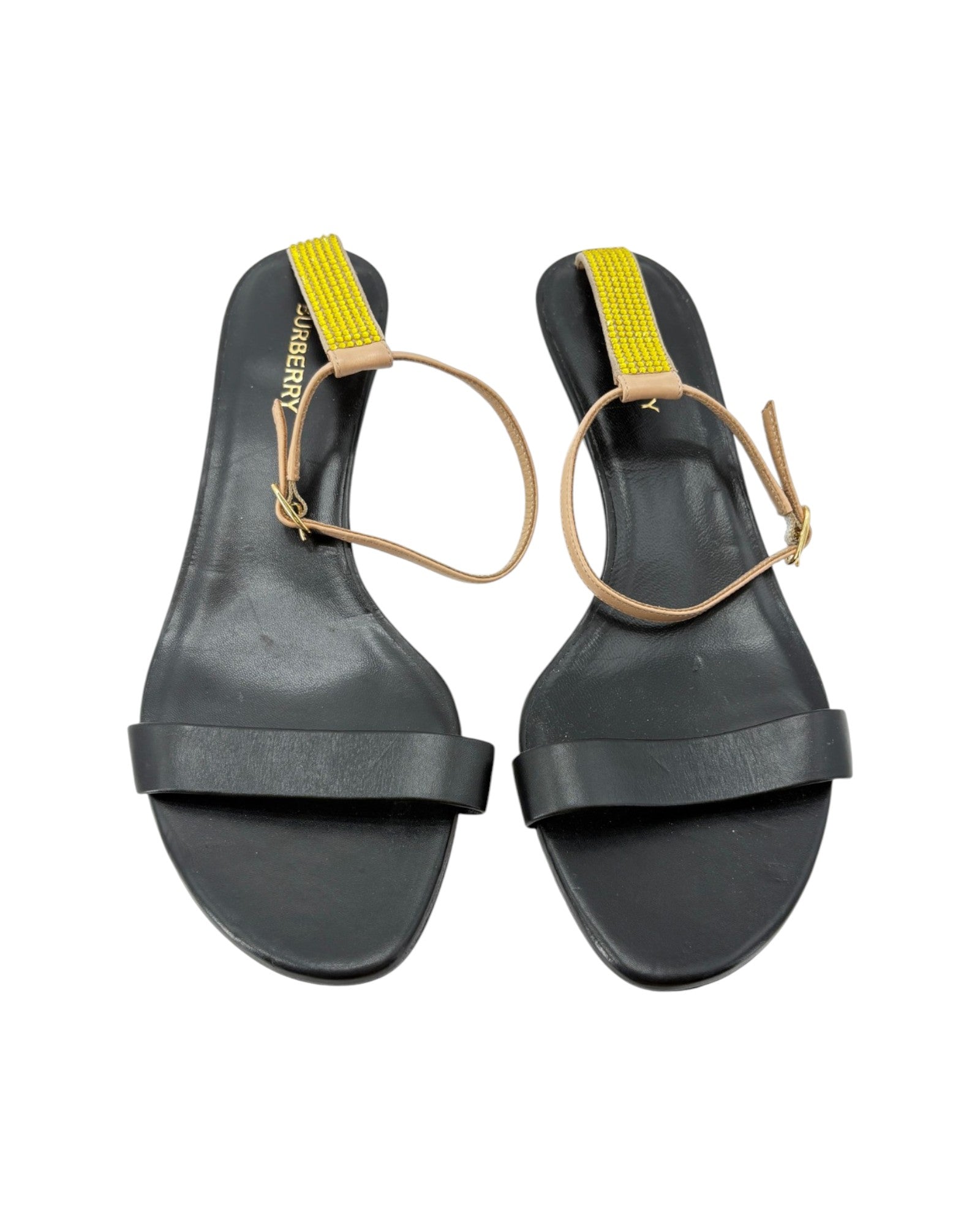 Black sandals with yellow straps on a white background