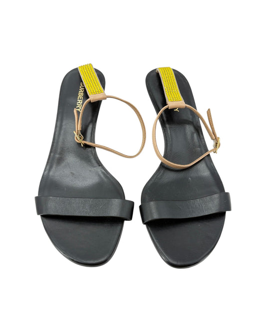 Black sandals with yellow straps on a white background