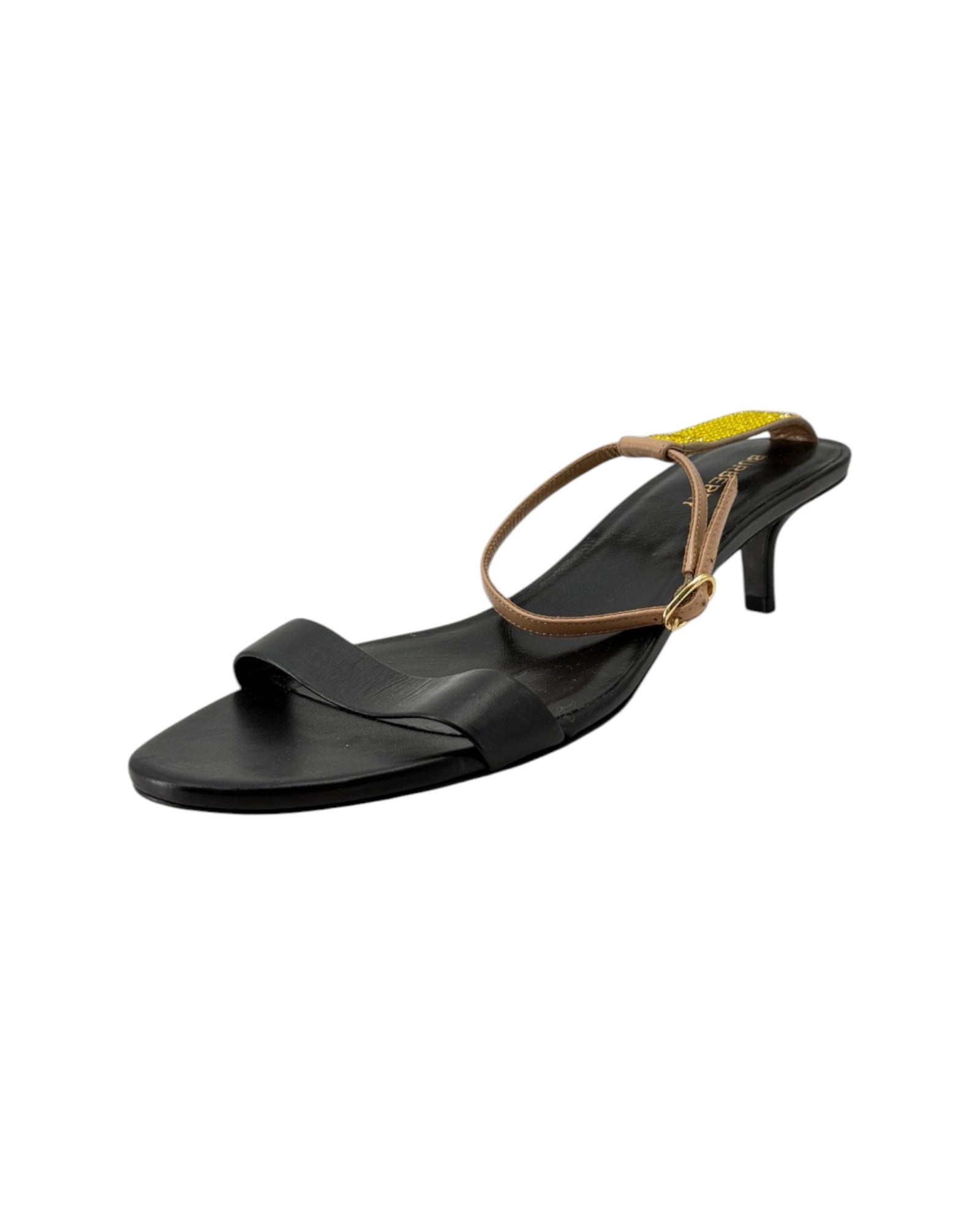 Black sandal with a thin tan strap on a white background