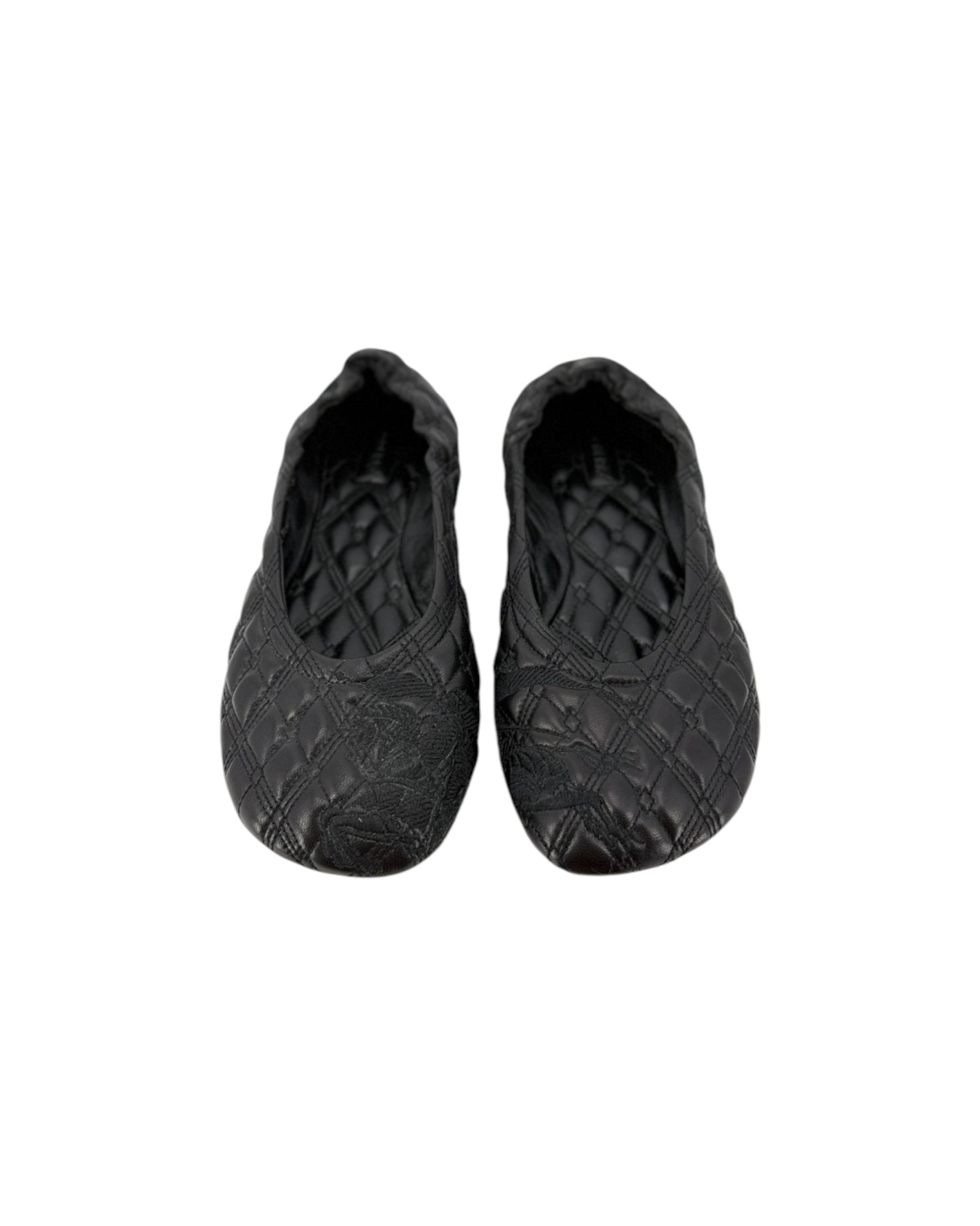 A pair of black quilted slip-on shoes with a textured, embossed pattern, shown against a plain white background.