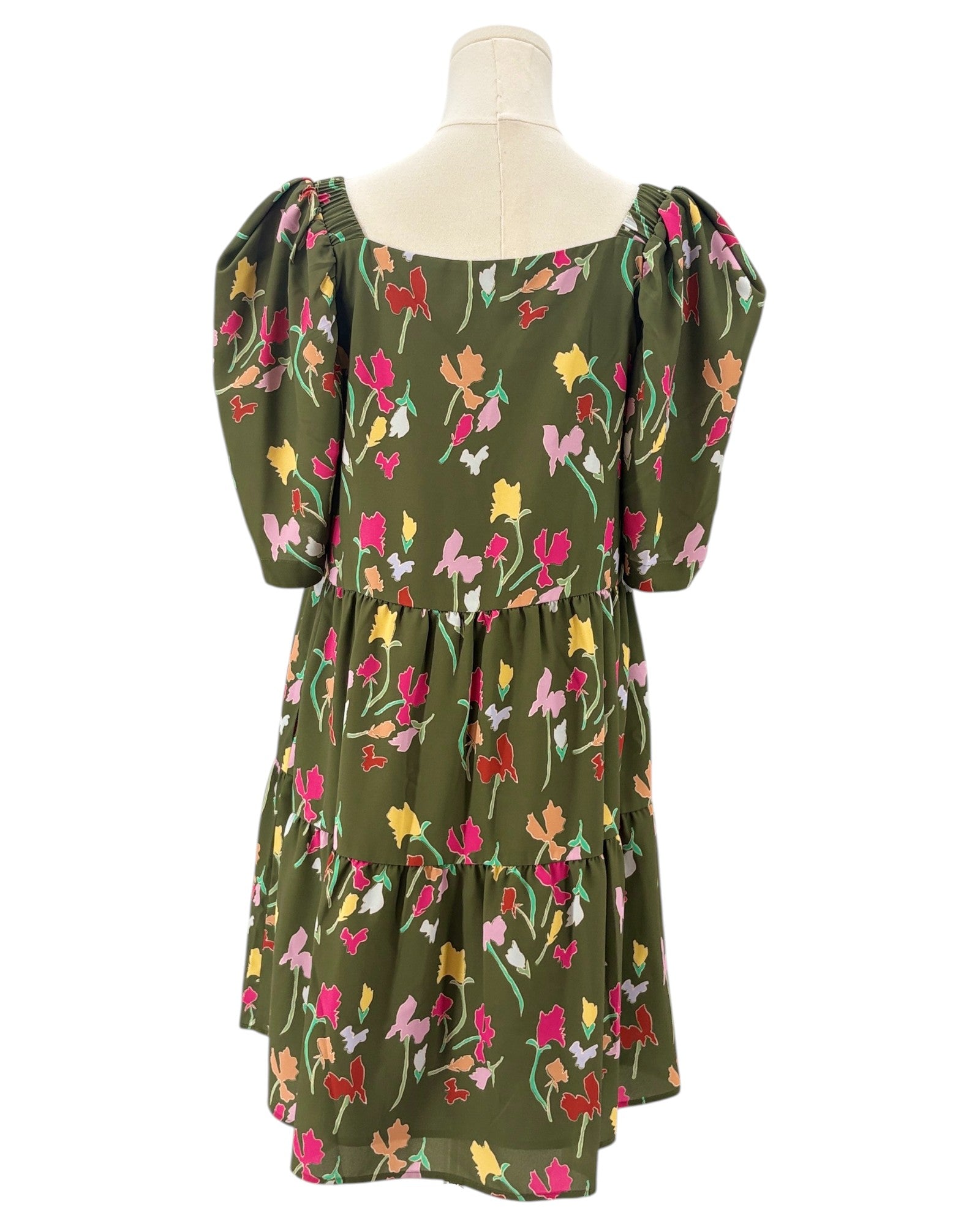 Green floral dress on a mannequin against a white background