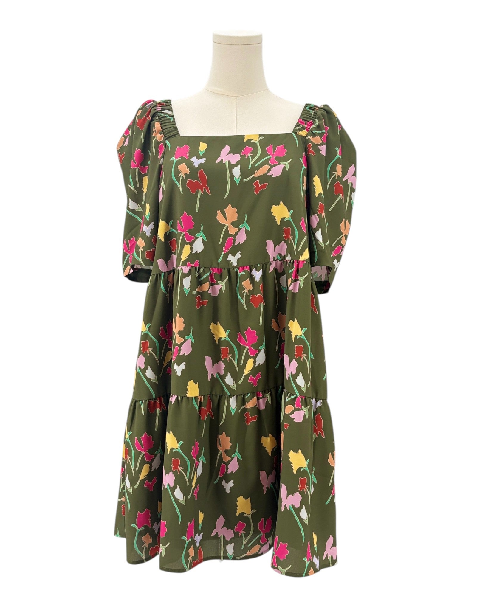 Green dress with floral pattern on a mannequin against a white background
