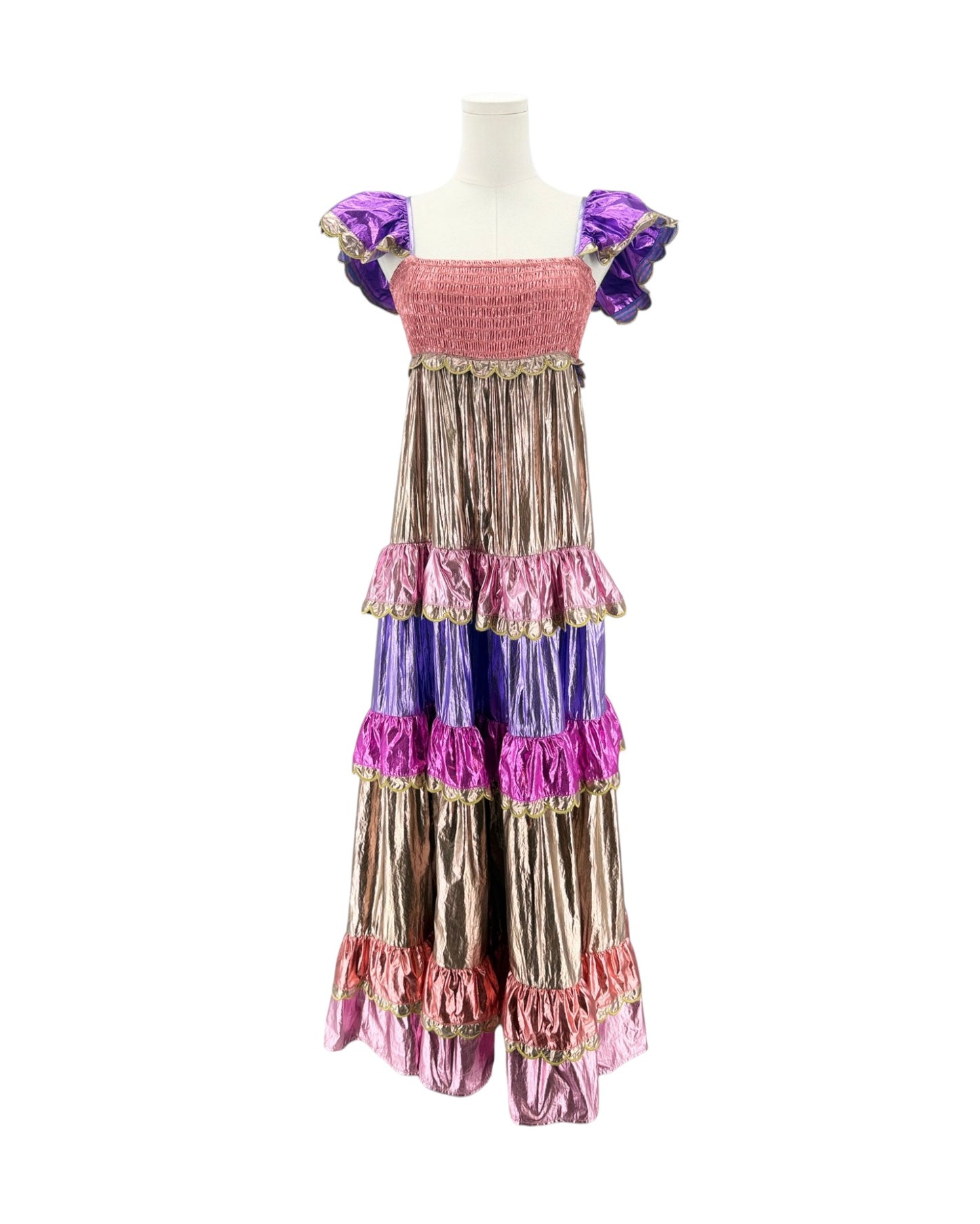 A long, tiered costume dress displayed on a mannequin against a plain white background. The dress features a pink smocked bodice, purple ruffled cap sleeves, and multiple tiers of metallic bronze, purple, and pink fabric with gold trim.