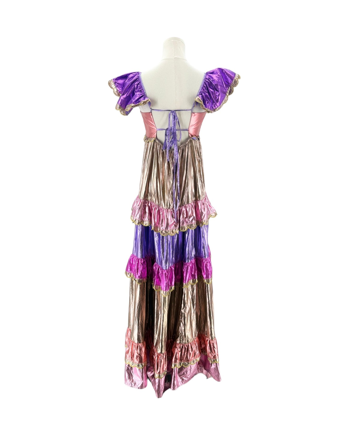 A vintage-style ruffled maxi dress displayed on a mannequin, featuring metallic gold and purple tiered layers with pink ruffle accents and puffed purple sleeves.