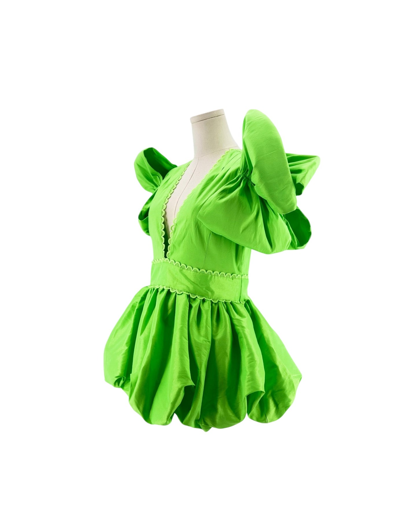 A bright lime green costume dress displayed on a white mannequin torso against a plain white background. The dress features dramatic, oversized puff sleeves, a deep V-neckline with decorative trim, and a voluminous ruffled skirt.