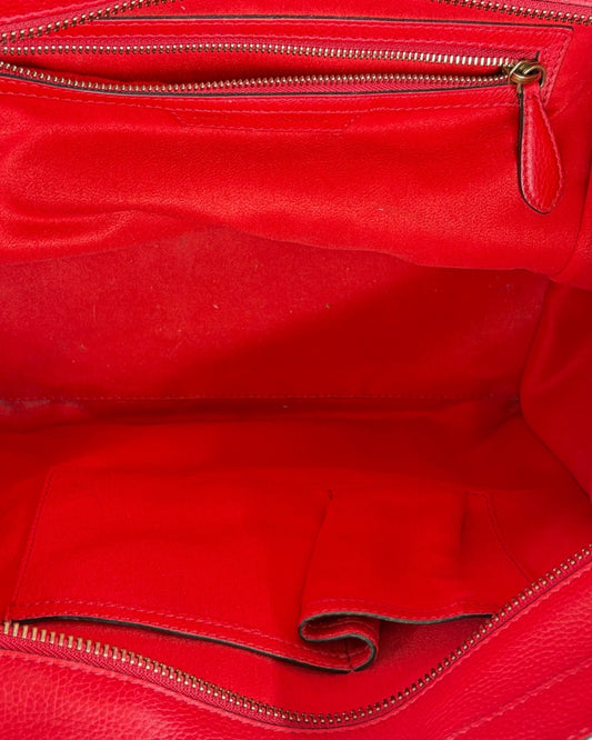 Close-up of a red leather bag with gold zipper
