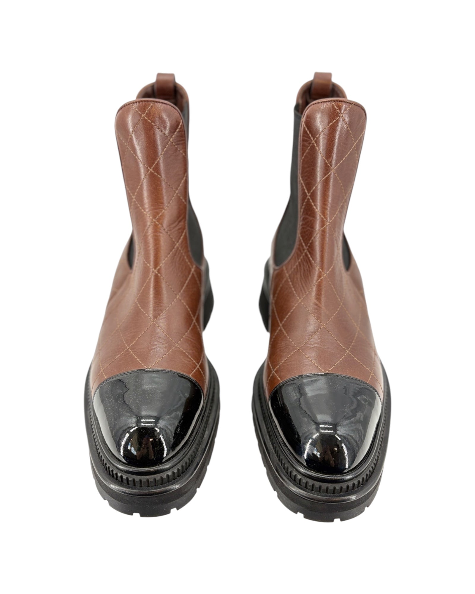 Pair of brown leather boots with black soles on a white background