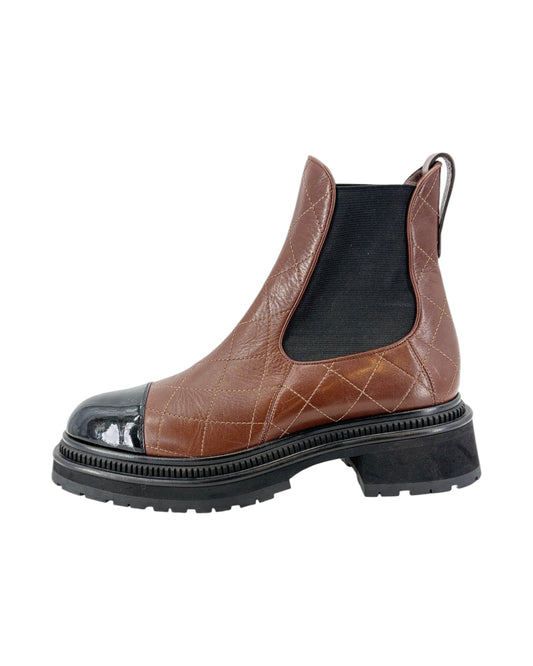 Brown leather Chelsea boot with black sole on a white background