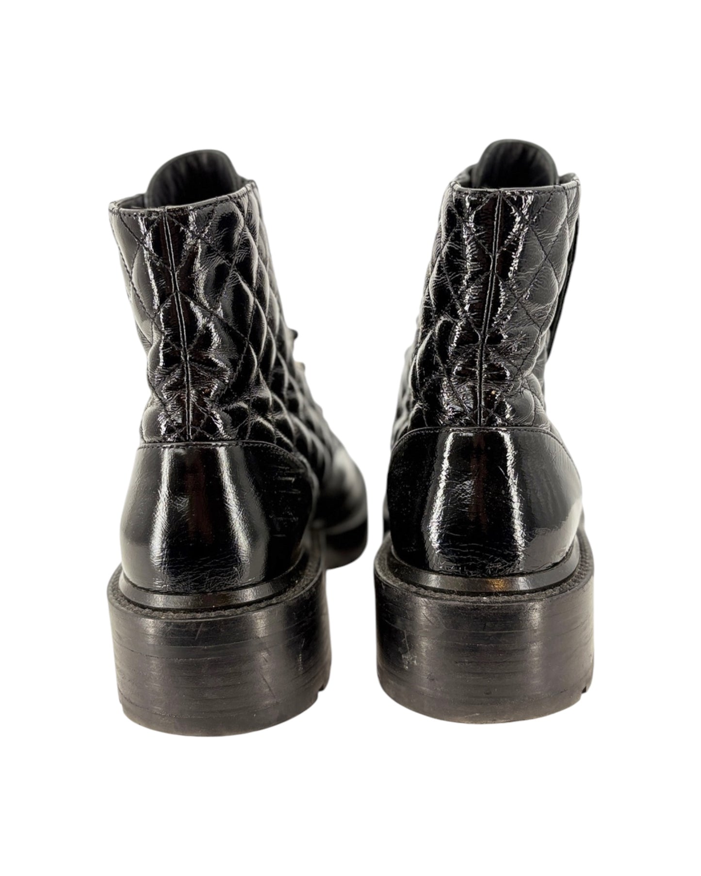 Black leather boots with detailed sole design on a white background