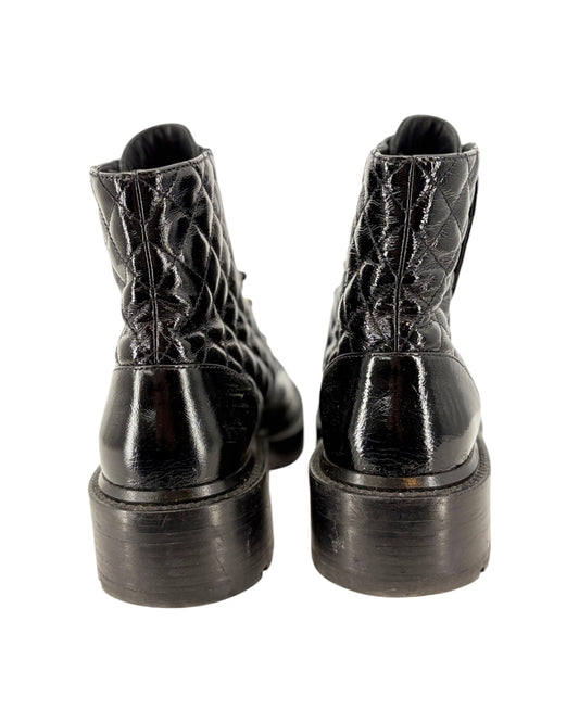 Black leather boots with detailed sole design on a white background