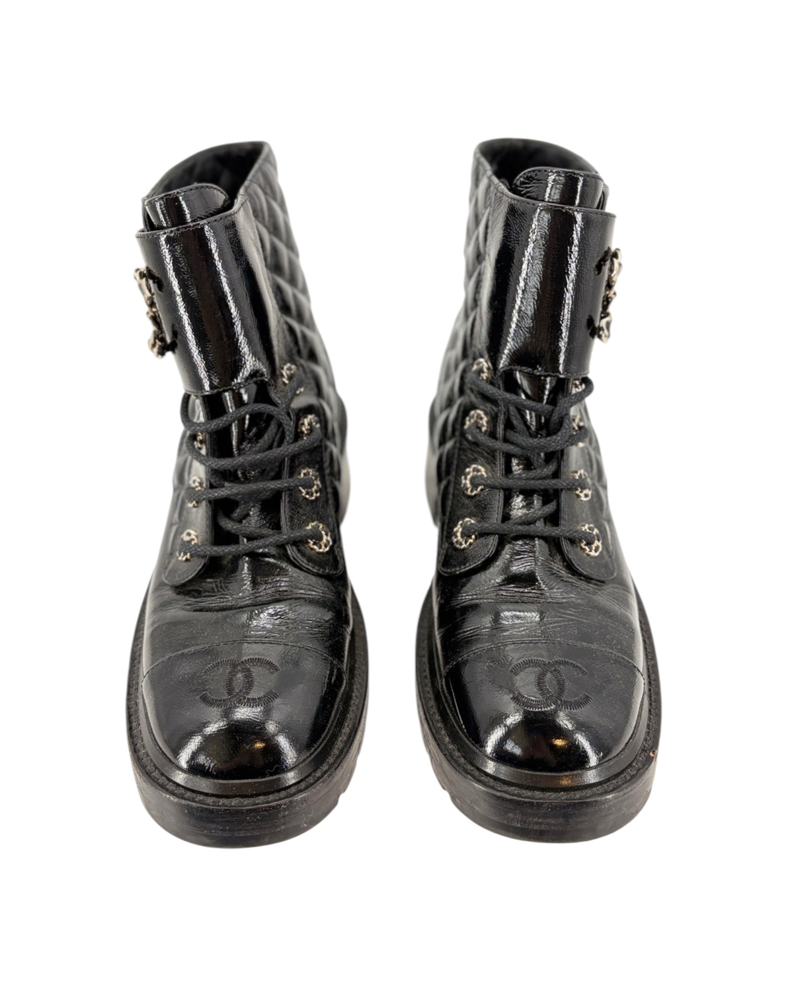 Pair of black leather boots with Chanel logo on a white background