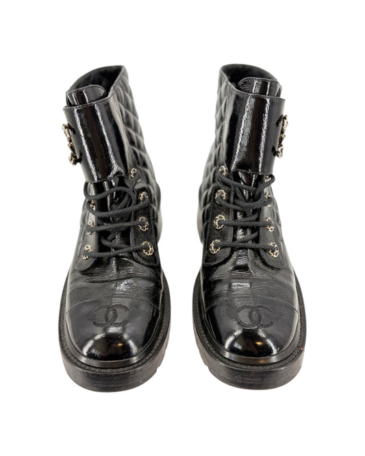 Pair of black leather boots with Chanel logo on a white background