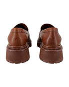 Chanel brown leather loafers shown from the back on a white background