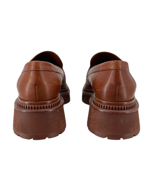 Chanel brown leather loafers shown from the back on a white background