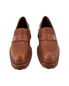 Pair of Chanel brown loafers with gold CC logo on a white background