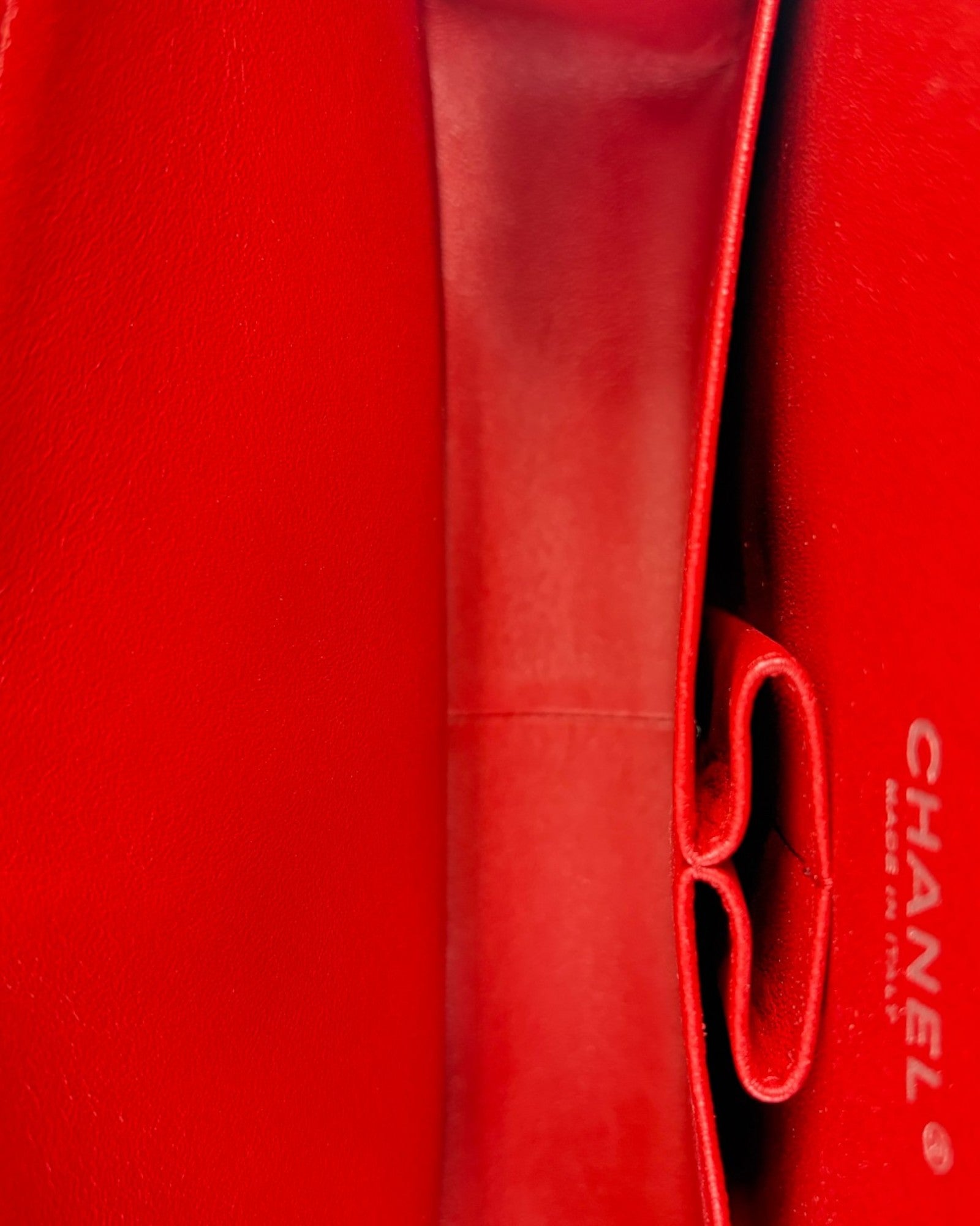 Close-up of a red Chanel handbag with visible branding.