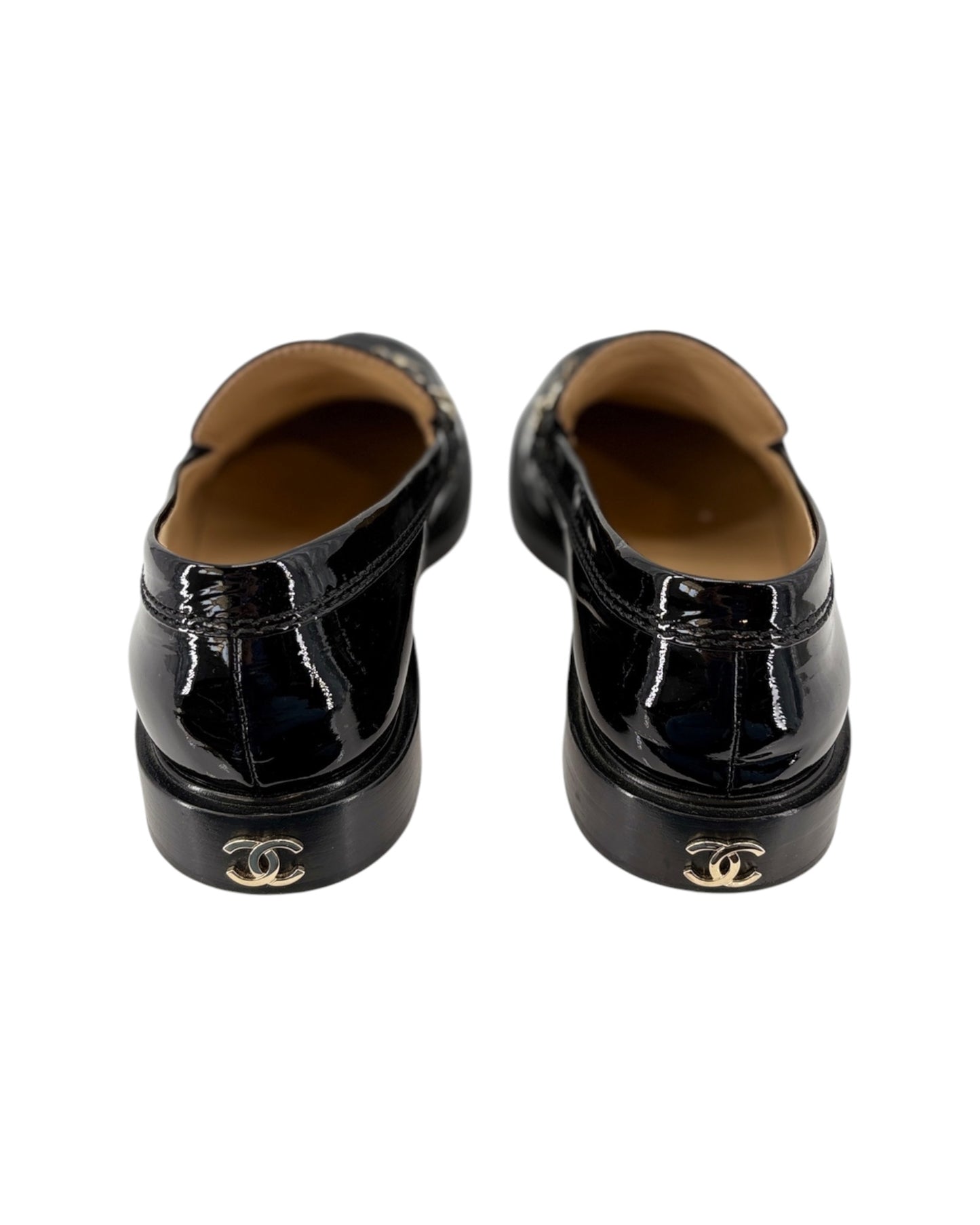 Chanel black patent leather loafer with gold chain detail on a white background