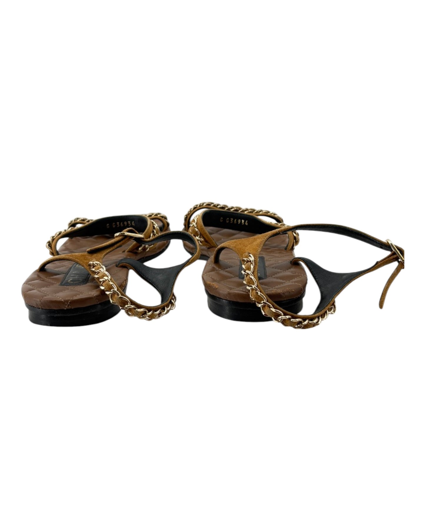 Pair of sandals with gold chains on a white background