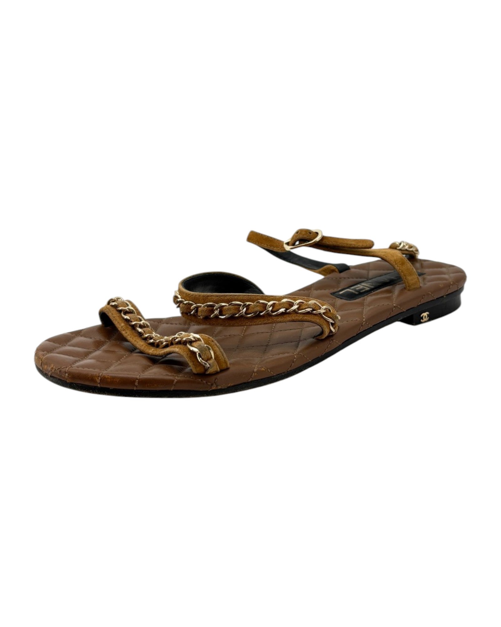 Brown sandal with gold chain detail on a white background