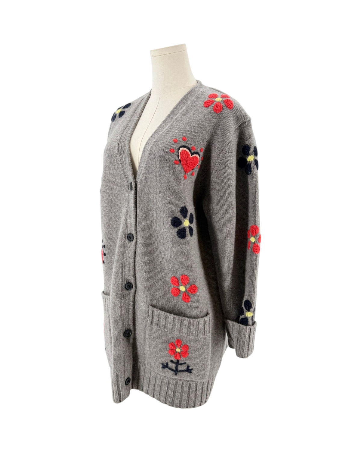 Grey button front cardigan with red floral and heart embroidery on a mannequin with a white background