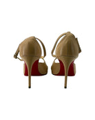 Tan high-heeled shoes with red soles on a white background