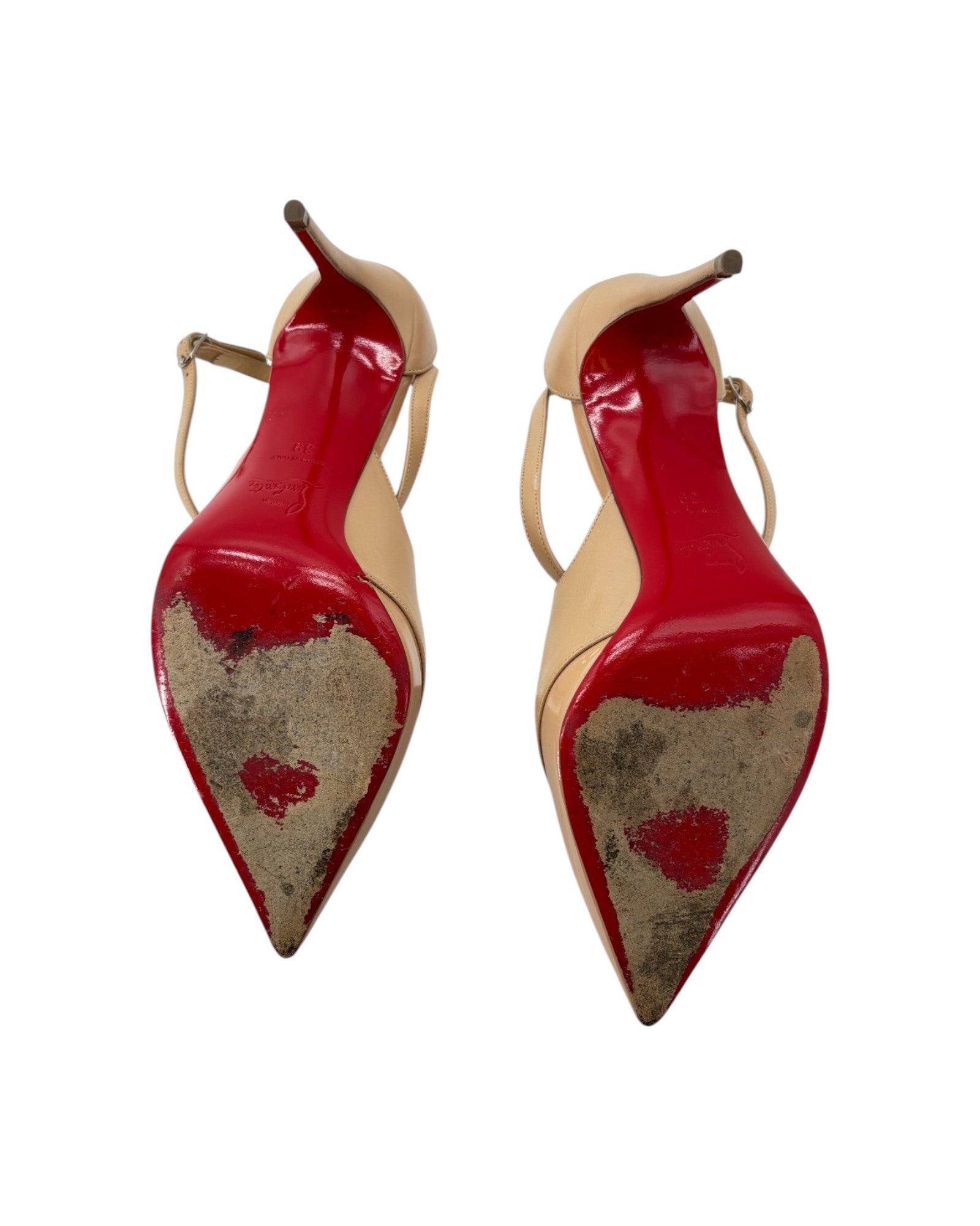 Pair of high-heeled shoes with red soles and beige heels on a white background