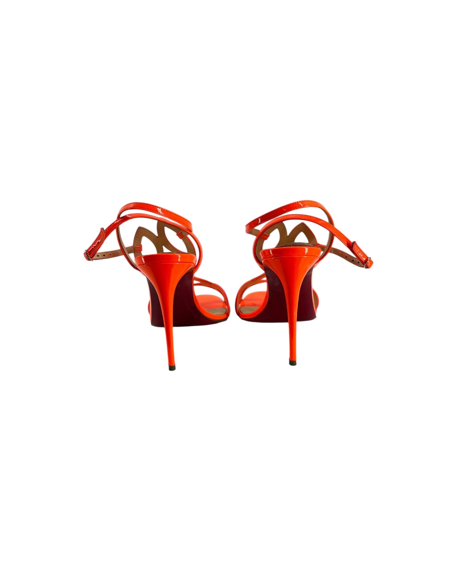 Pair of orange high-heeled shoes on a white background
