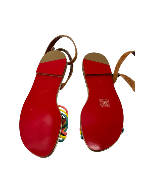 Red bottom sandals with multicolored straps on a white background
