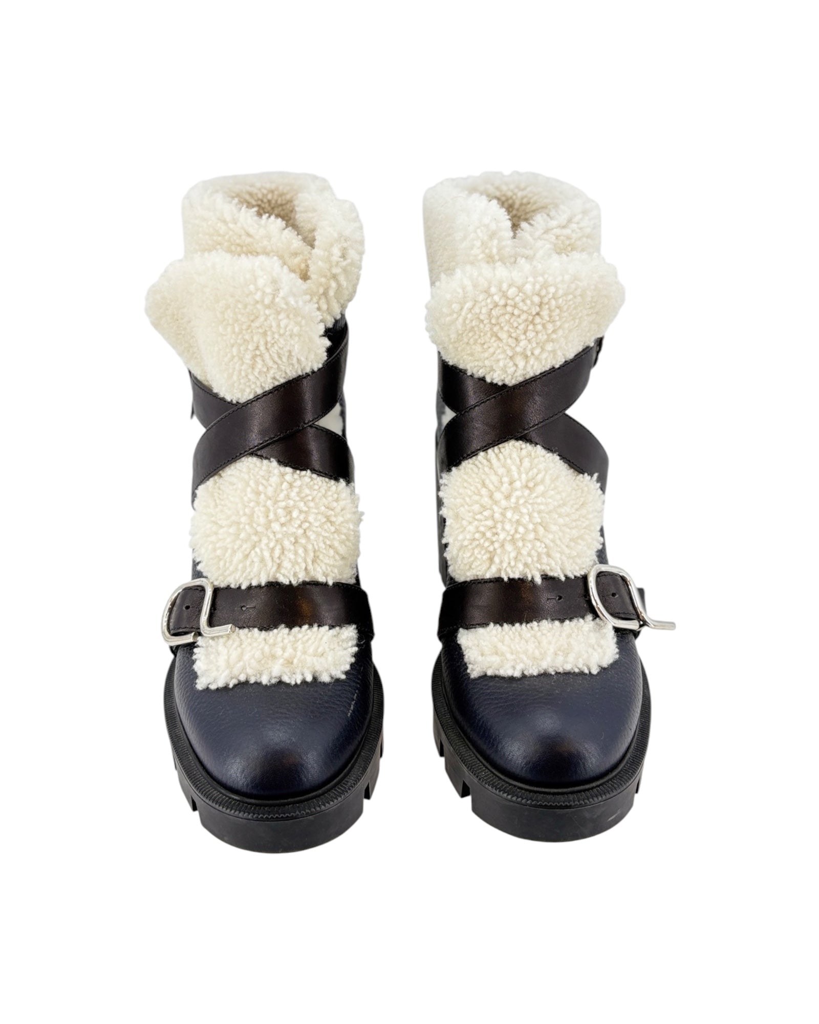Pair of black boots with white shearling lining on a white background