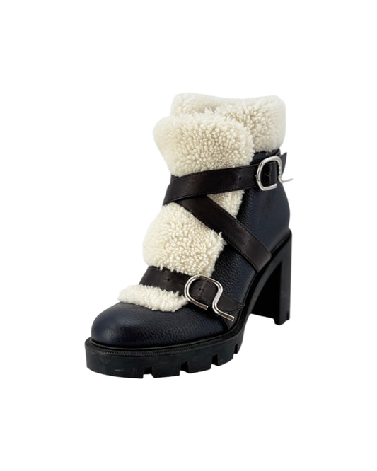 Black boot with white fur lining on a white background
