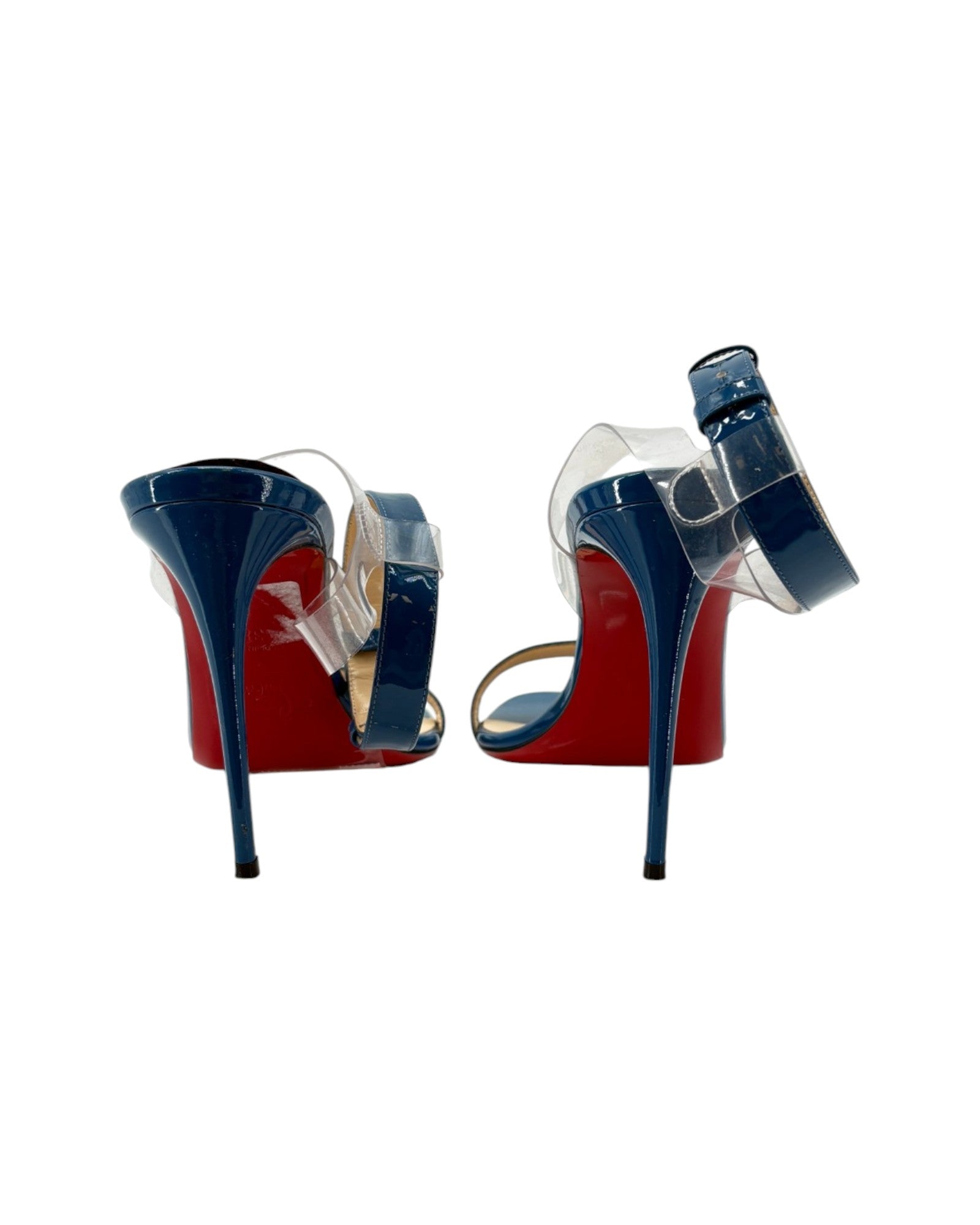 Pair of high-heeled shoes with red soles and blue transparent straps on a white background