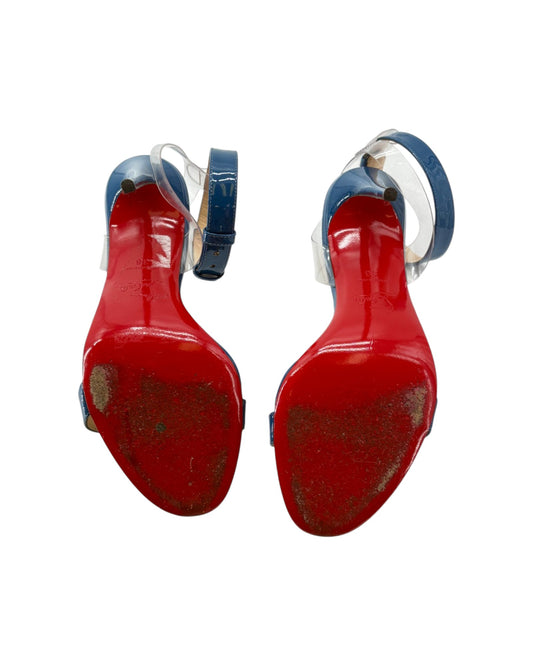 Red bottom high-heeled shoes with blue straps on a white background