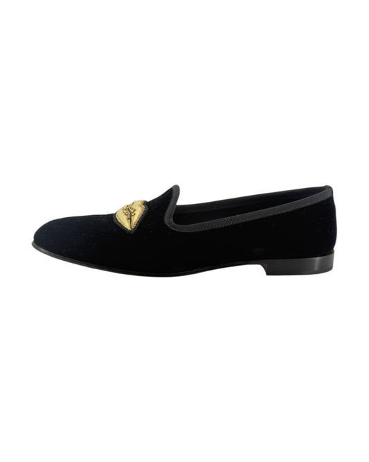 Black velvet loafer with gold heart detail on a white background