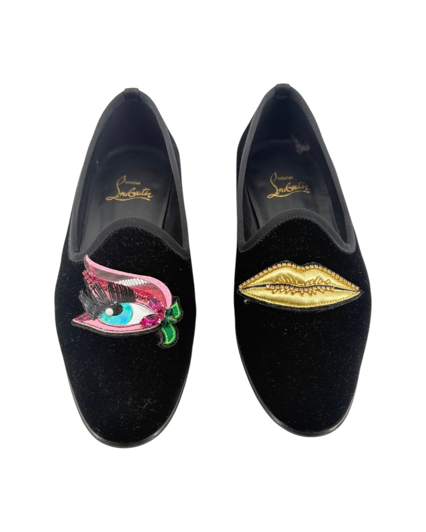 Black velvet shoes with decorative embellishments on a white background