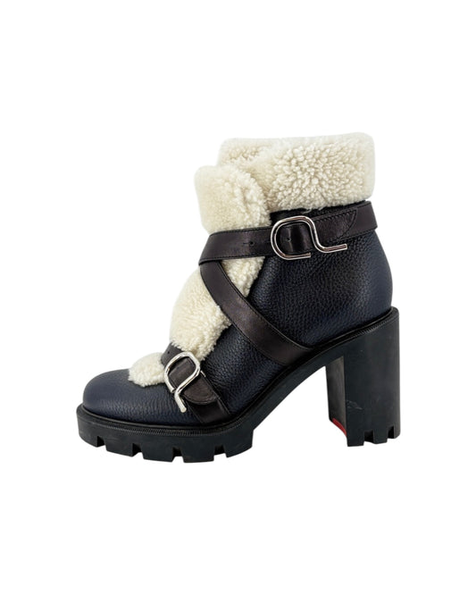 Black leather boot with white fur lining and buckles on a white background