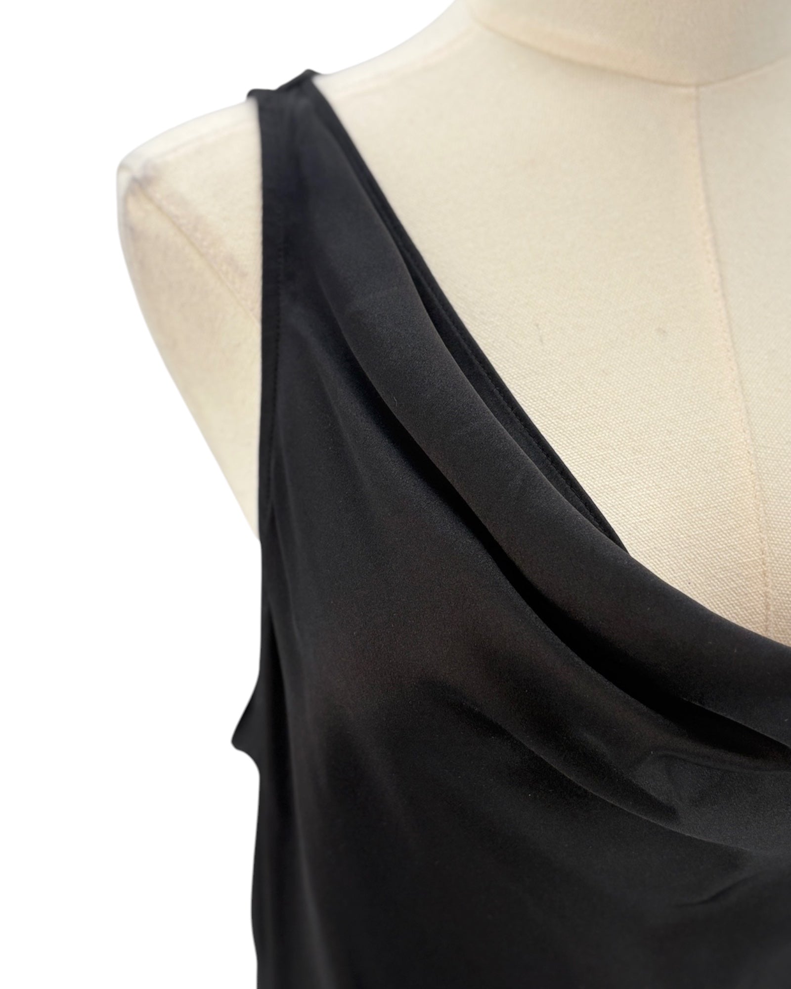 Black one-shoulder top on a mannequin with a white background