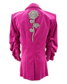 Pink blazer with a decorative silver flower on the back against a white background