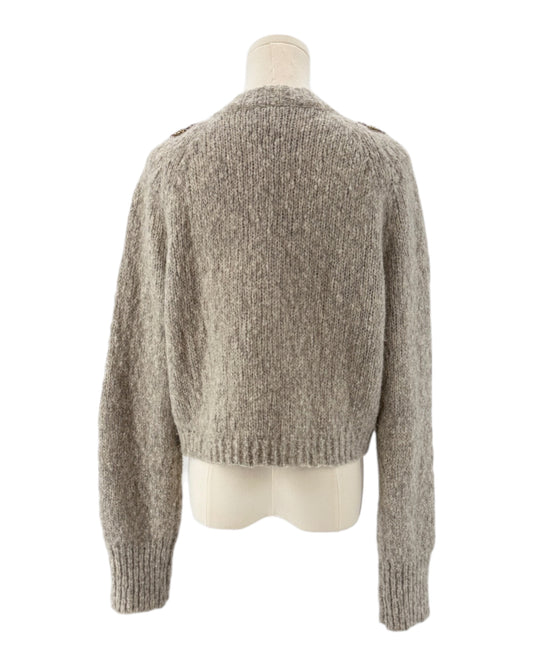 Knitted cardigan with floral embellishments on a mannequin against a white background