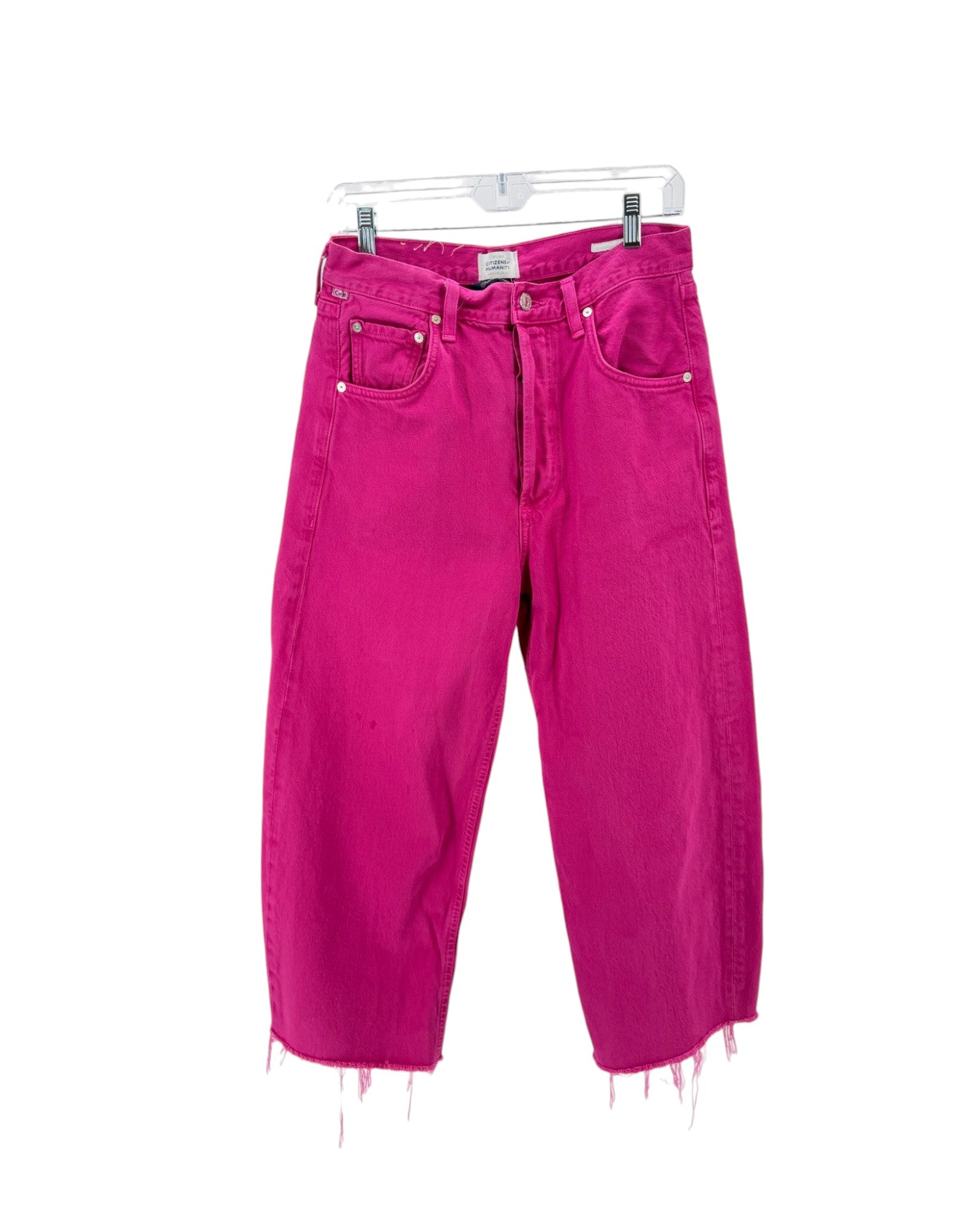 Pink jeans with frayed hems on a white background