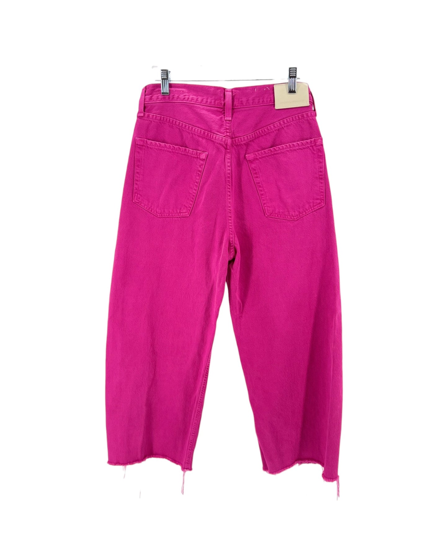 Pink pants hanging on a white background