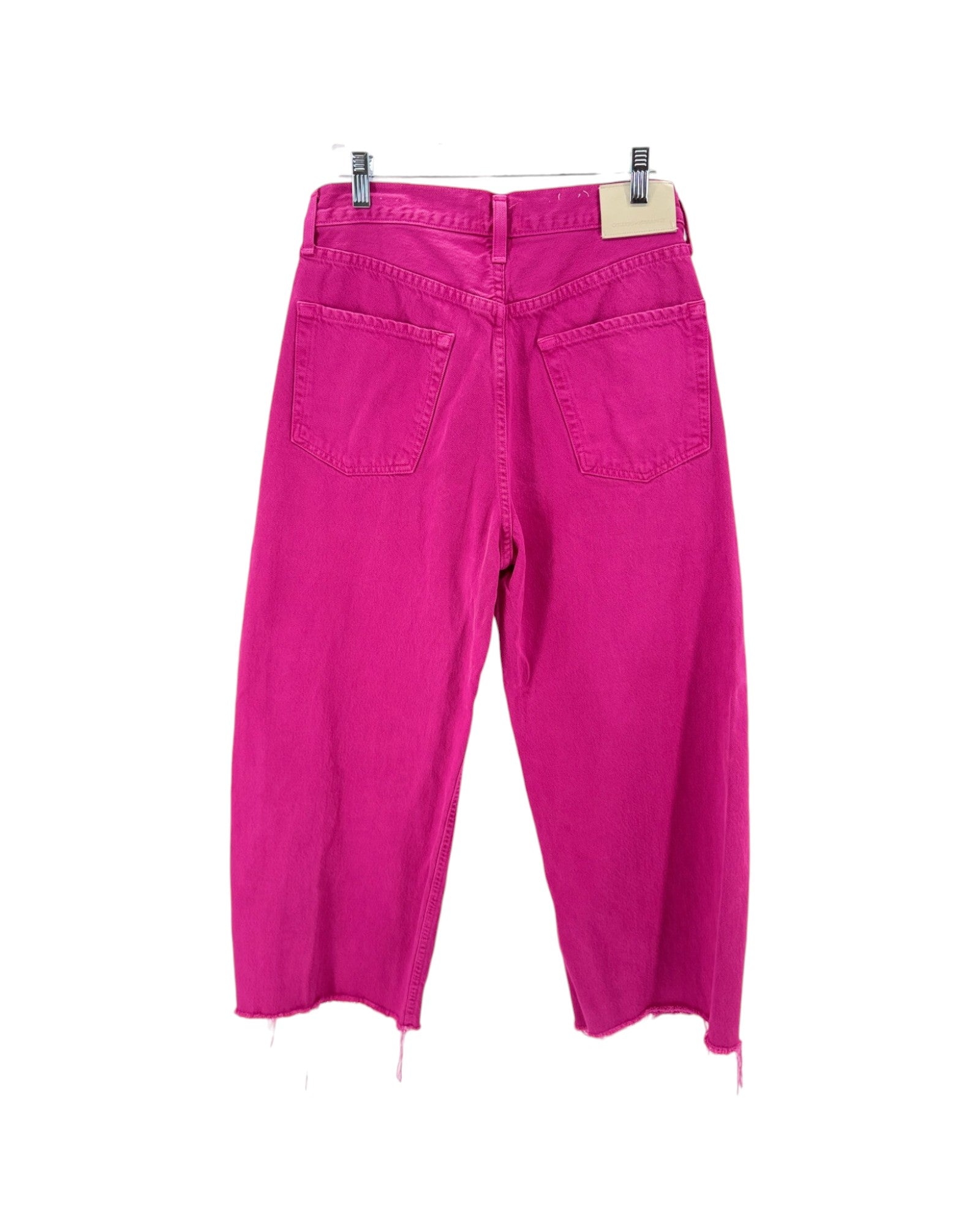 Pink pants hanging on a white background
