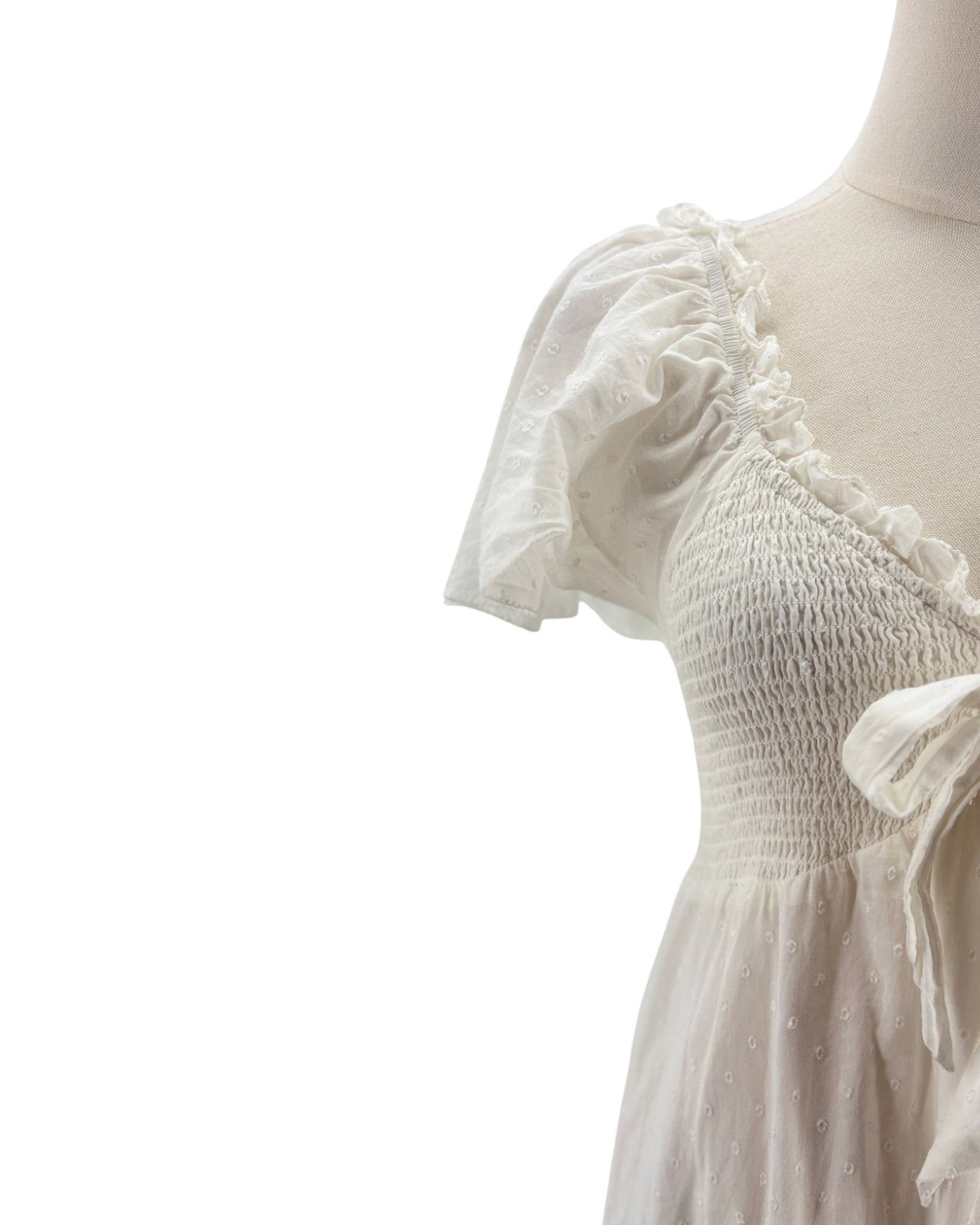 White dress with ruffled sleeves on a mannequin against a white background