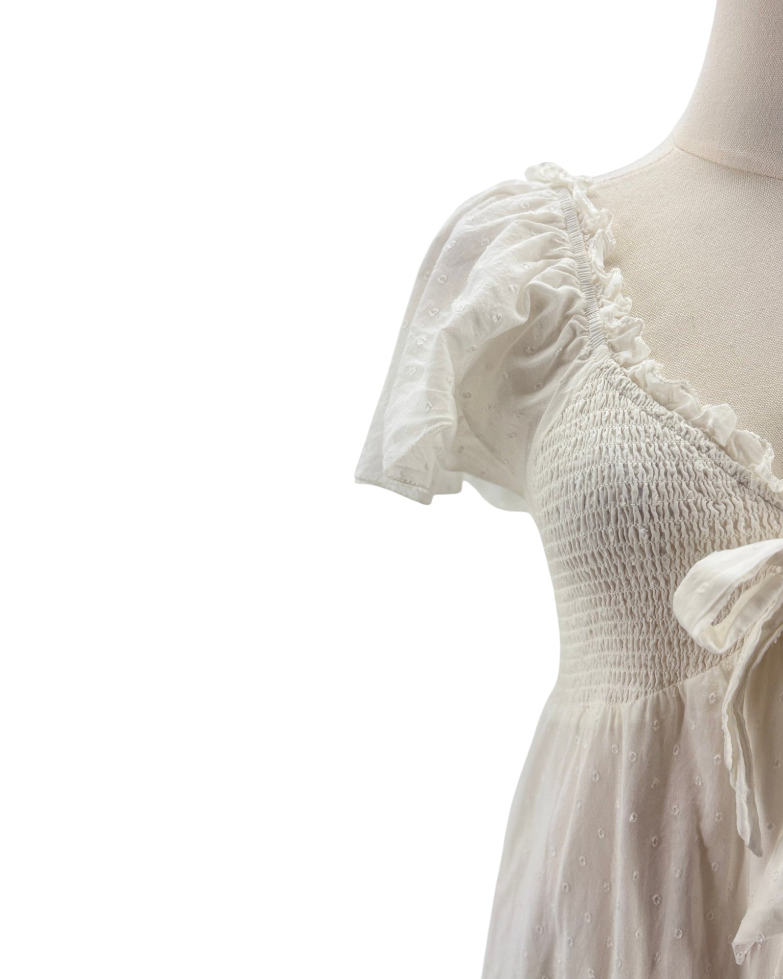 White dress with ruffled sleeves on a mannequin against a white background