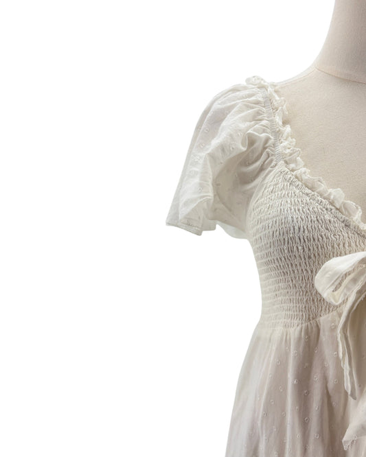 White dress with ruffled sleeves on a mannequin against a white background
