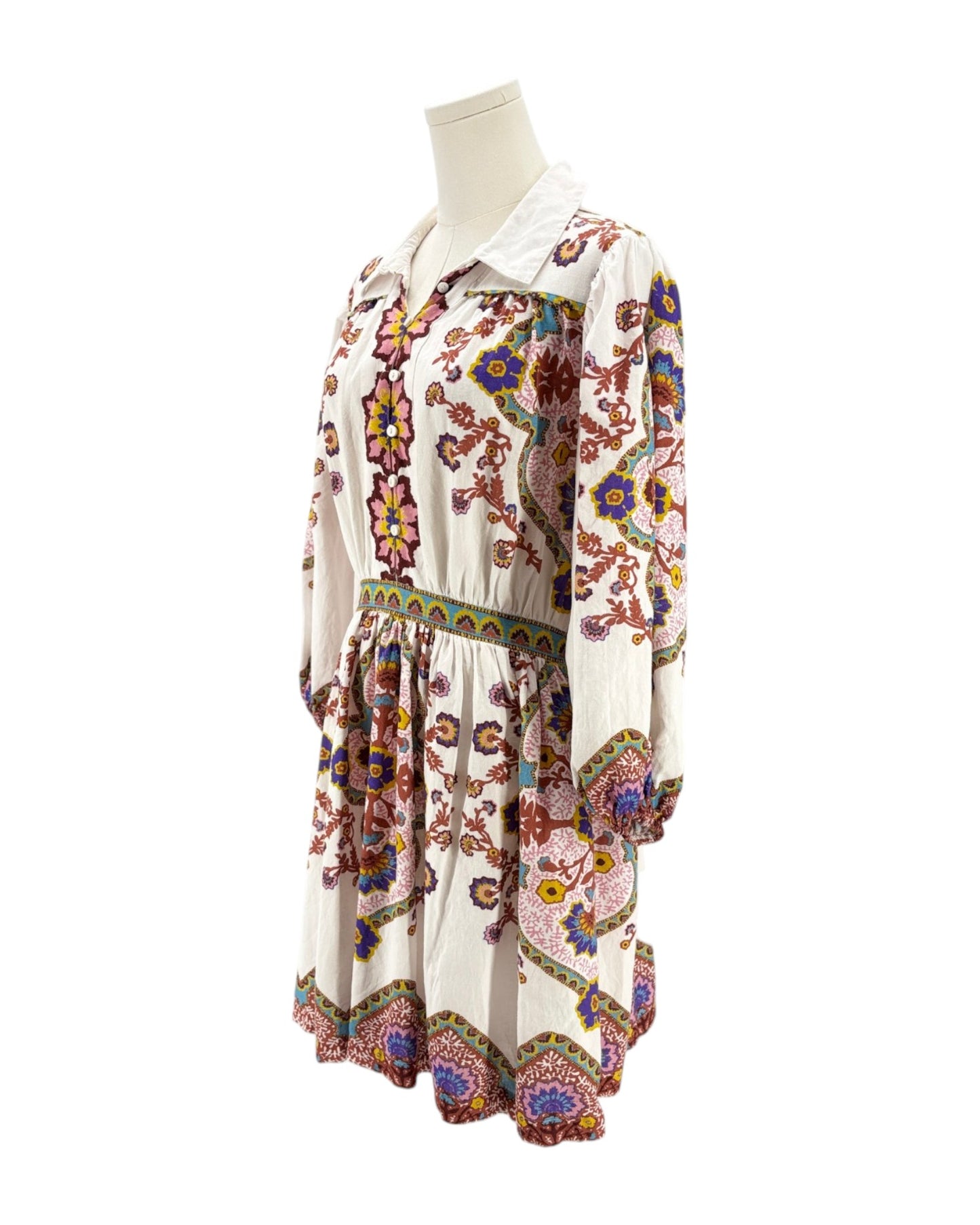 Colorful floral dress on a mannequin against a white background