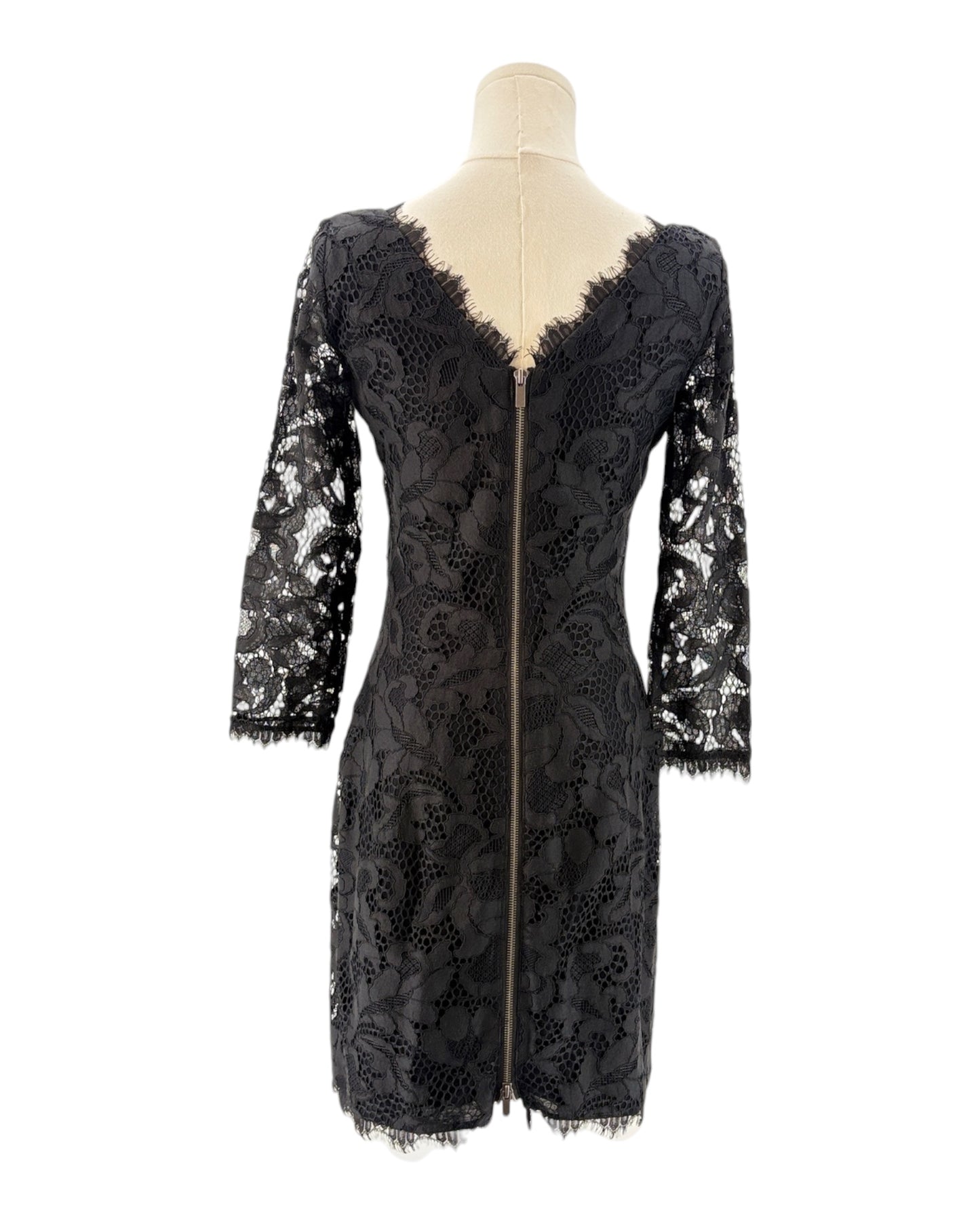 Black lace dress on a mannequin against a white background