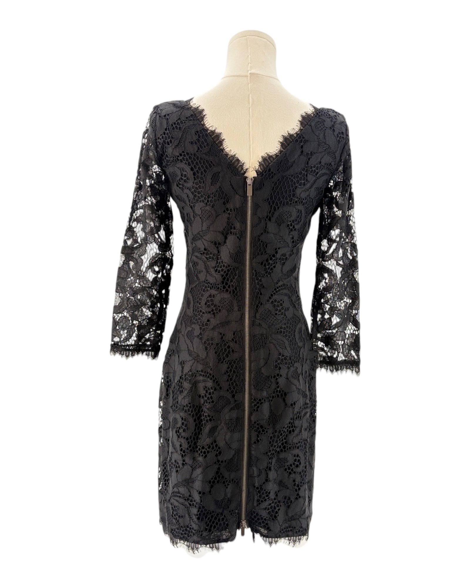 Black lace dress on a mannequin against a white background